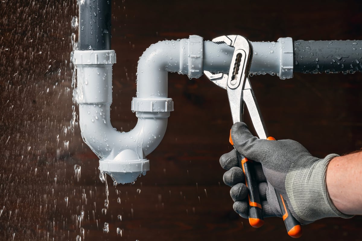 Plumber fixing emergency water leak